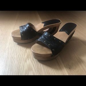 Wooden clogs with black leather and brass rivets